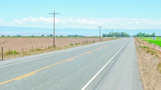 Highway 14/16/20 in Emblem divides two fields; one planted, and the other left fallow due to low water availability Tuesday, July 7. Avery Howe