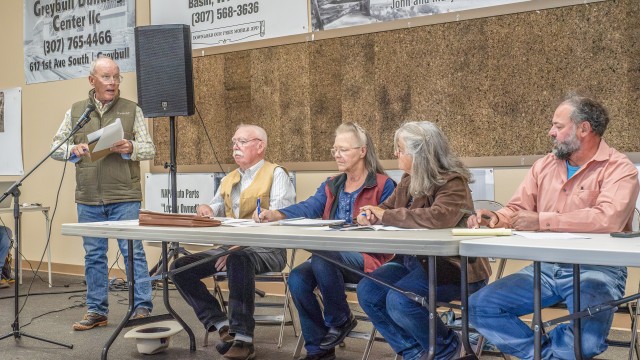 Downstream landowner Tim Gardiner, left, speaks during public comment at a special Nowood Watershed Improvement District meeting Saturday, Oct. 17 in Hyattville Community Center. Gardiner has been a strong critic of alleged conflicts of interest and lack of transparency regarding the Alkalai Creek Reservoir project. Pictured at the board table, from left, are attorney Vigil Kinnaird, Treasurer Sheri Mascaro, Vice Chair Terri O’Donnell and Chair Martin Mercer. Avery Howe